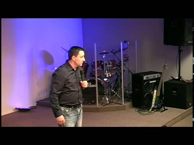 Pastor Ruslan Murin preaching with a microphone on the church stage