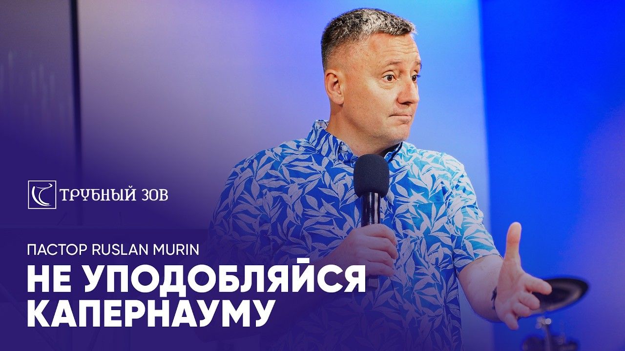 Ruslan Murin preaching into a microphone and gesturing with one hand.