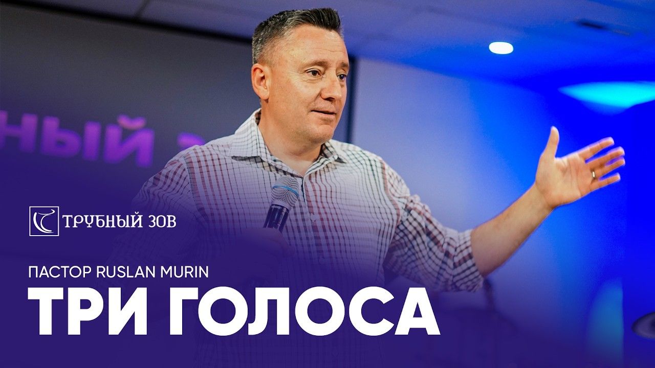 Ruslan Murin in a checked shirt preaching with a microphone, one arm stretched out to the side.