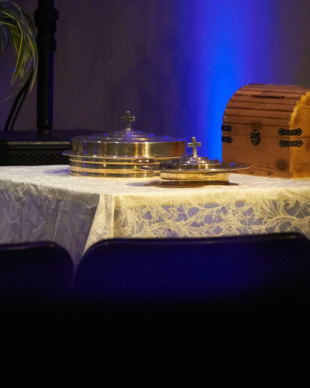 Communion trays and a wooden chest on a lace-covered table