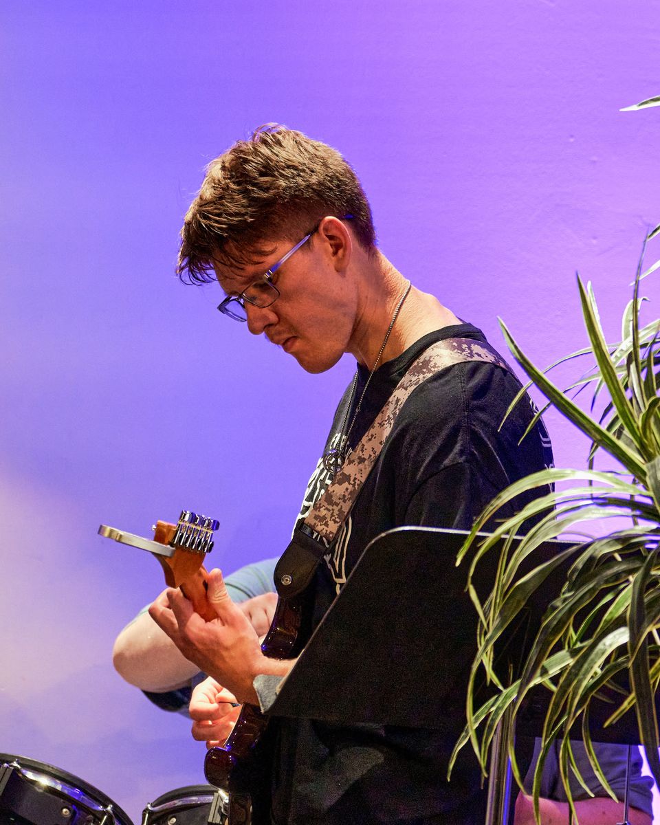 A guitarist bent over his guitar
