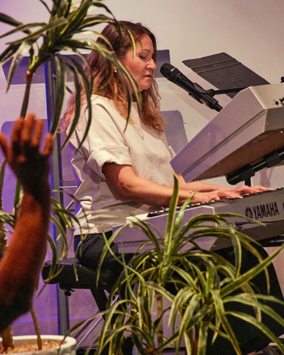 A woman singing at a keyboard