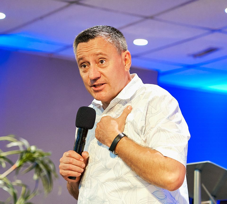 Pastor Ruslan Murin speaking into a microphone during a service