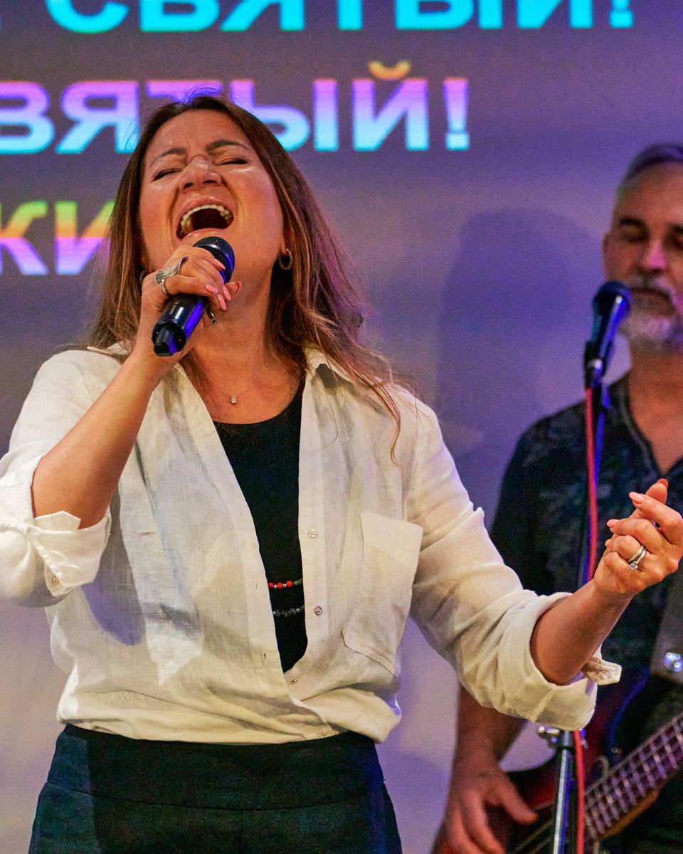 A vocalist singing with her eyes closed